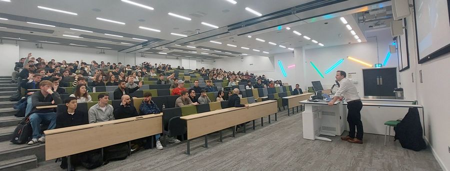 Image shows Piers Curran running the event in a busy lecture theatre